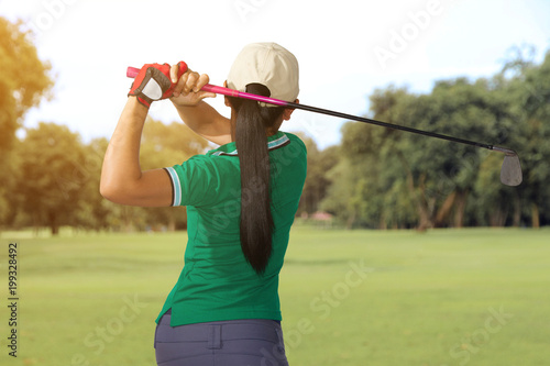 Woman player golf swing shot on course 