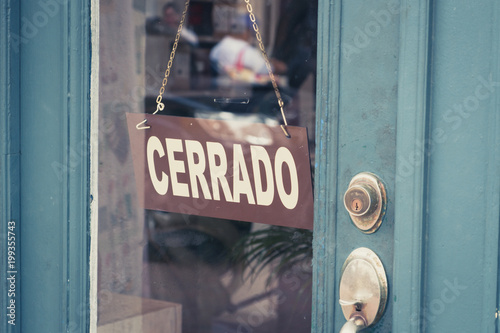 Cerrado (closed) sign on door - spanish word "cerrado" (closed) on shop entrance -