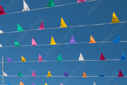 Colorful, triangular bunting on a background of blue sky on a sunny day.