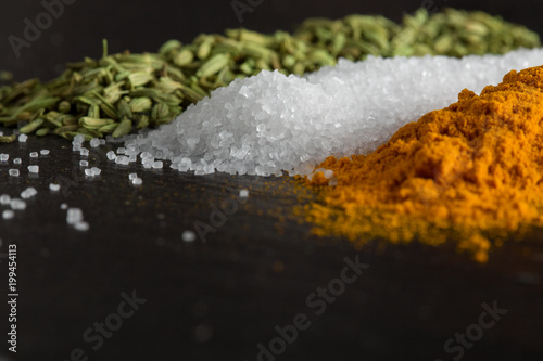 sea salt among spices on the stone surface