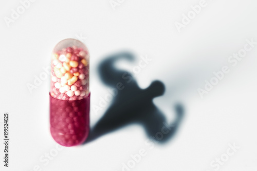 Sports doping, anabolic capsule - shape of a male muscular upper body - symbol for medical drug abuse.