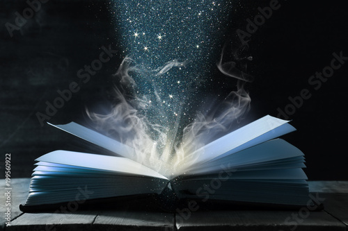 image of open antique book over wooden table.