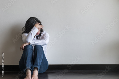 Panic attack, anxiety disorder menopause woman, stressful depressed emotional person with mental health illness, headache and migraine sitting back against wall on the floor in domestic home