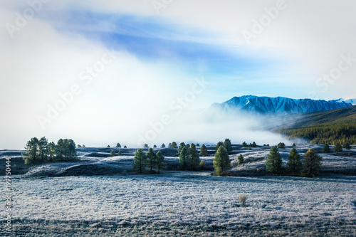 Fog in the mountain valley. Morning fog over the lake in the Altai mountains.