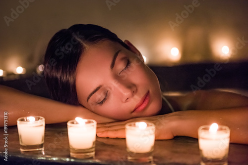 Relaxing woman sleeping in luxury spa resort in massaging hydrotherapy jets in whirlpool jacuzzi hot tub. Stress free meditation.