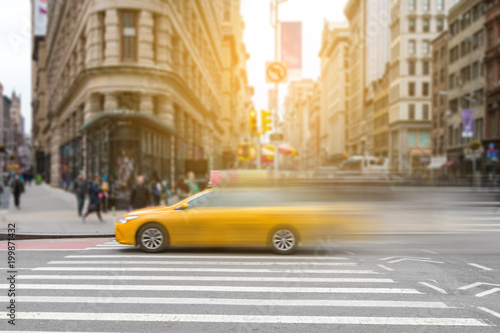 New York City yellow taxi cab in motion across broadway