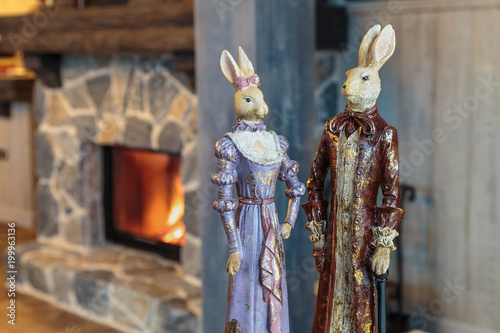 toy miniature figures of rabbits in the image of a lady and gentleman in old clothes on the background of vintage interior