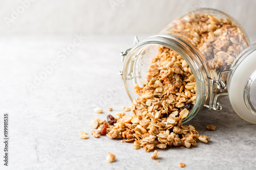 Fresh granola in glass jar on gray stone background