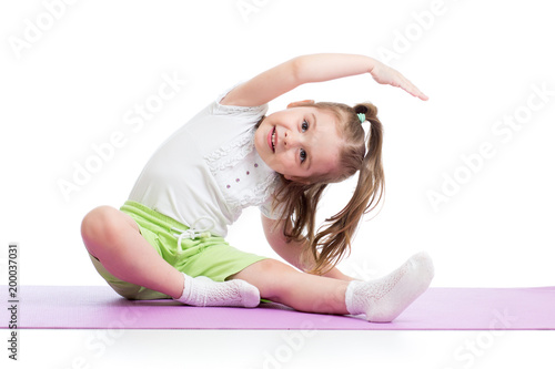 Child girl practicing yoga, stretching in exercise wearing sportswear. Kid isolated over white background