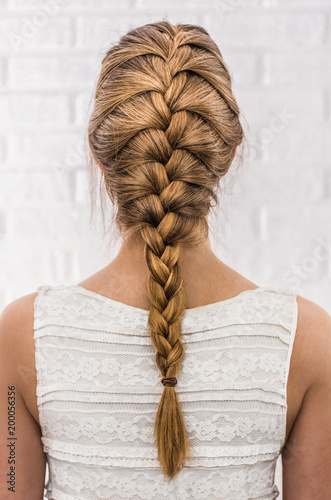 Head of a young woman from behind. Rear view braid