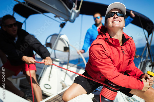 Attractive strong woman sailing with her boat