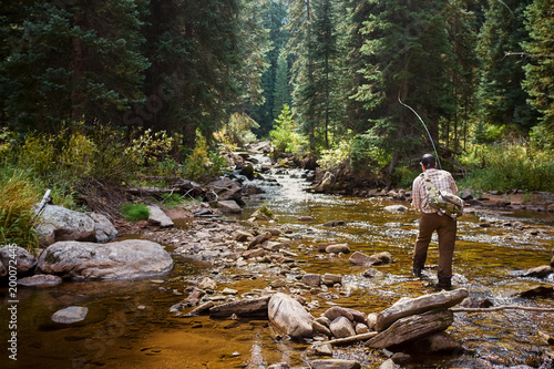 River fisherman fishing in mountain creek