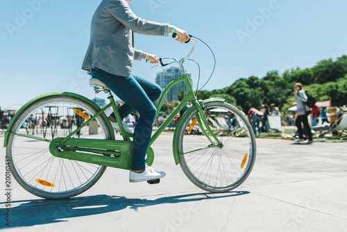 A stylish man rides a beautiful city park bike ride. Walk on a bike. Active rest. Walking bicycle