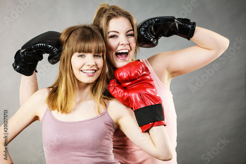 Two women friends wearing boxing gloves