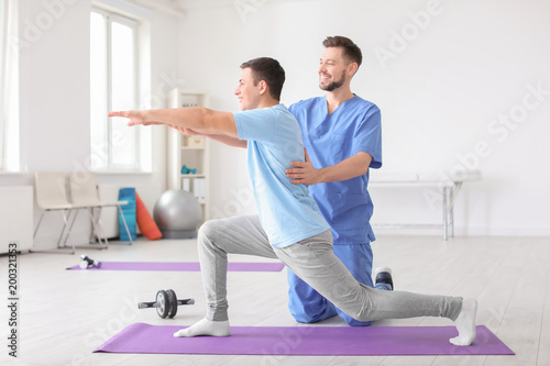 Physiotherapist working with male patient in clinic