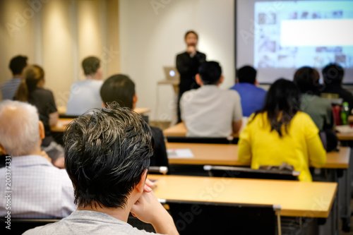 Audience listening speaker who standing in front of the room at the conference hall, Business and Entrepreneurship concept.