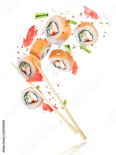 Pieces of fresh sushi with chopsticks frozen in the air, isolated on white background