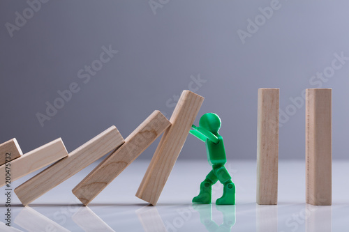 Human Figure Stopping Wooden Dominos Blocks