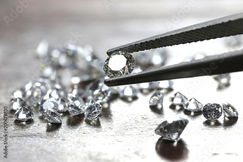 brilliant cut diamond held by tweezers