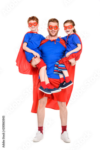 super father carrying happy kids in masks and cloaks isolated on white