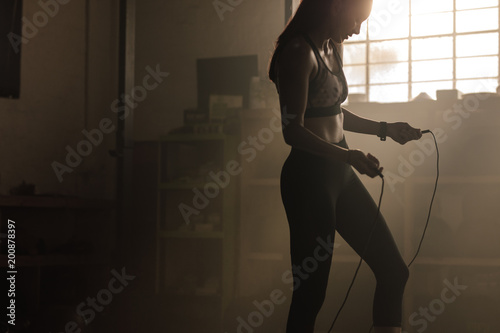 Female exercising with skipping rope at gym