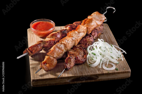 Traditional Russian shashlik on a barbecue skewer on black background