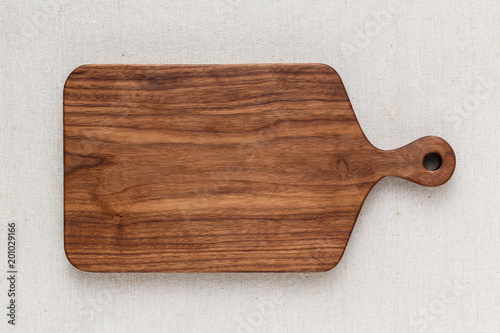 Walnut handmade wood cutting board on the linen