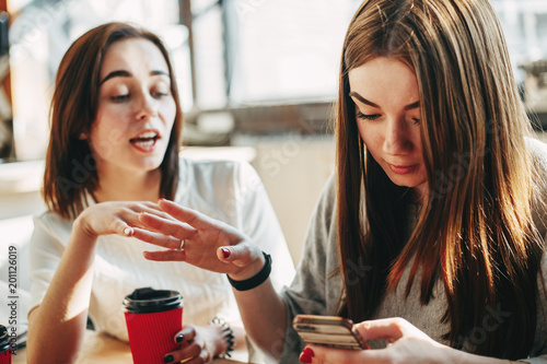 Woman trying to speak to her inattentive friend