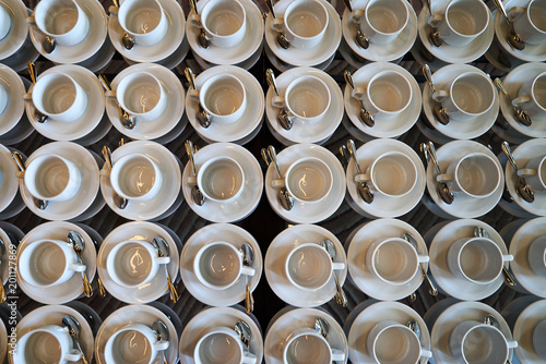 Set of Empty white ceramic tea or coffee cup and saucers, top view. Group of empty cups stacked in rows for serving coffee in restaurant