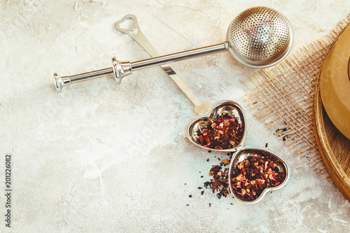 Metal tea infuser with leaves. Composition with tea accessories on a white background