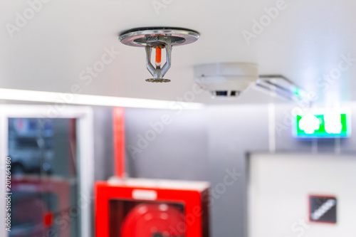 Fire Sprinkler, focus at selective, Fireplace in the office for safety and to reduce damage in case of fire, signage exit blur background.