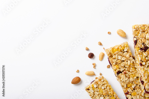 Energy bar of muesli with nuts, berries and oat flakes on a white background. Healthy food, granola for breakfast. Top view.