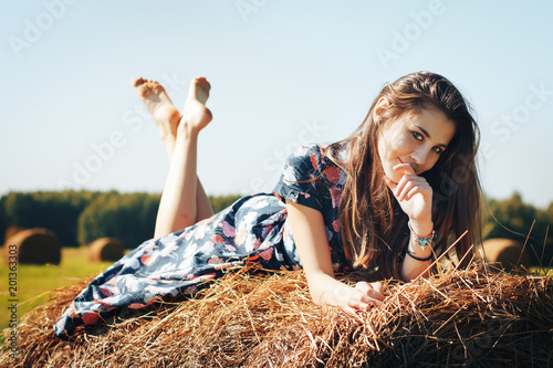 Teenager girl in an autumn field with hay stack