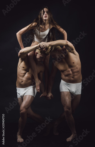 Circus gymnasts at pilates or yoga training. circus performers training isolated on black background.