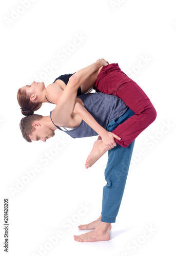 Young athletic couple practicing acroyoga. Balancing in pair.