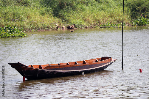 Sampan boat parked in the middle of the river. It is a small boat of a kind used in East Asia, typically with an oar or oars at the stern.