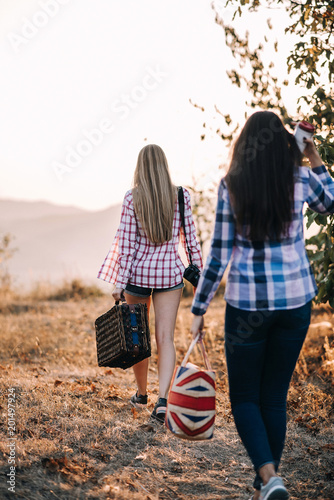 beautiful girl with shopping bags are on the mountain slopes to meet the sunset. the sun in her hair. road in the mountains. picnic