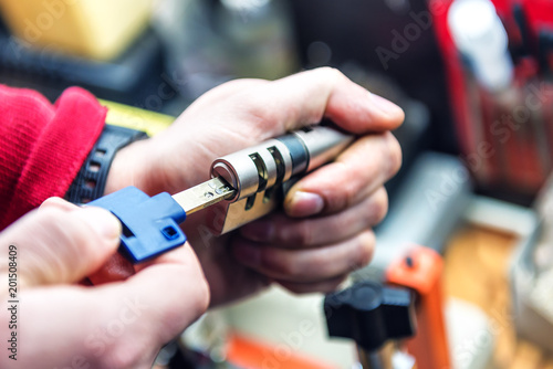 locksmith is testing door lock cylinder