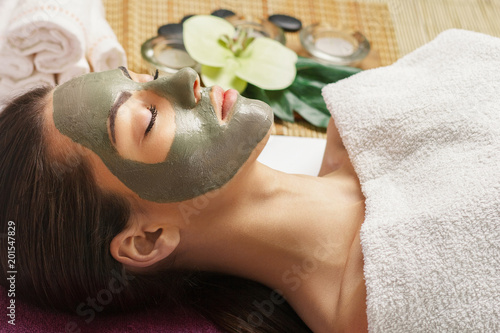 Face peeling mask, spa beauty treatment, skincare. Woman getting facial care by beautician at spa salon, close-up.Spa clay mask on femele face.