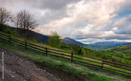 fence on a hillside of mountainous countryside. lovely rural scenery in springtime