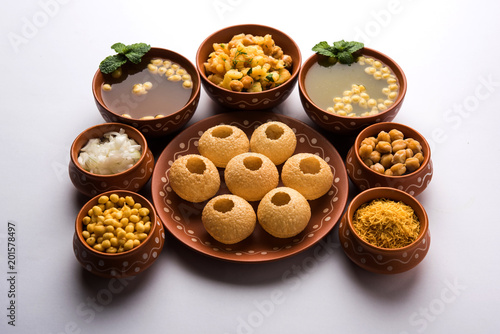 Pani Puri is Indian chat item served in a terracotta bowls and plate 