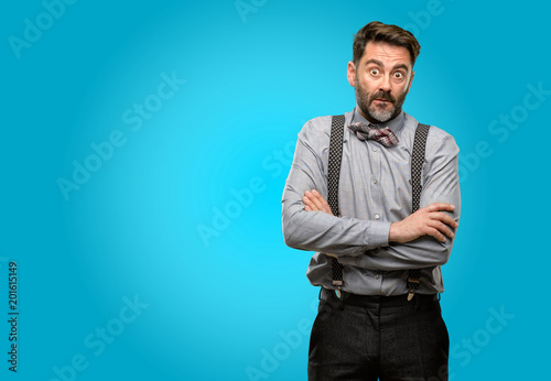 Middle age man, with beard and bow tie nervous and scared biting lips looking camera with impatient expression, pensive