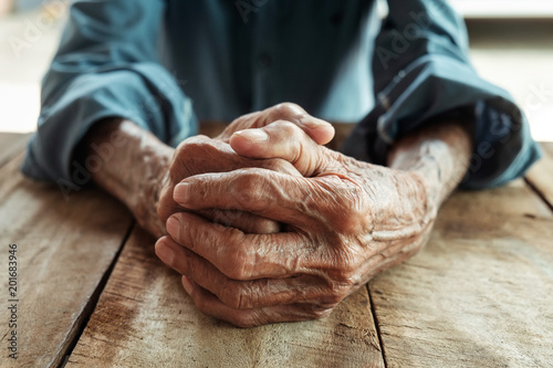 close up of elderly oldman hands on wooden table