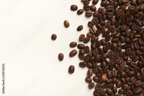 Heap of brown coffee beans isolated on white