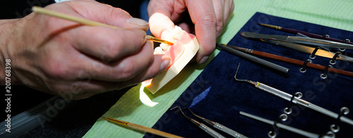Laboratory dentist technician working on prostetic tooth close