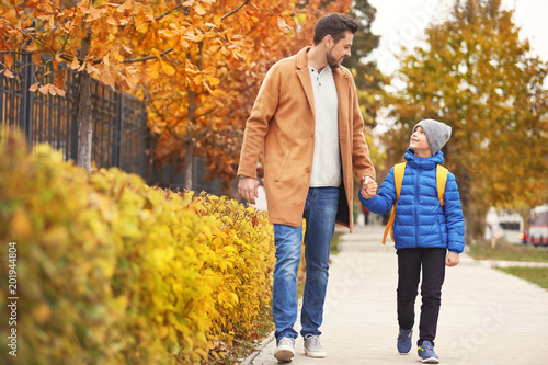 Cute little boy going to school with his father