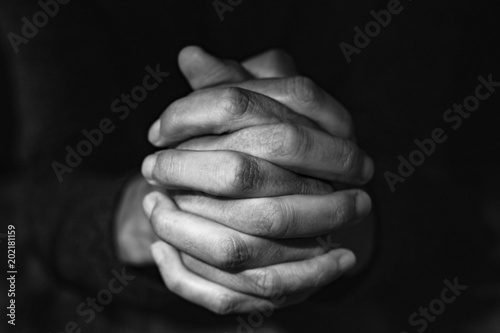 man with his hands clasped, in black and white