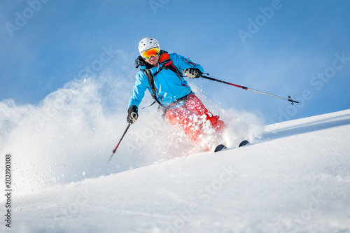 Mężczyzna narciarz freeride w górach poza trasą
