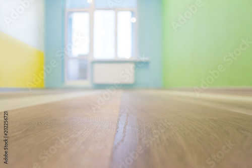 Empty kids room interior background with color walls and wooden flooring, shallow depth of focus