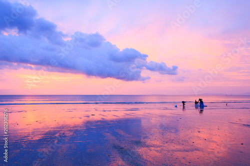 An Asian fisherman family on the sunset beach.